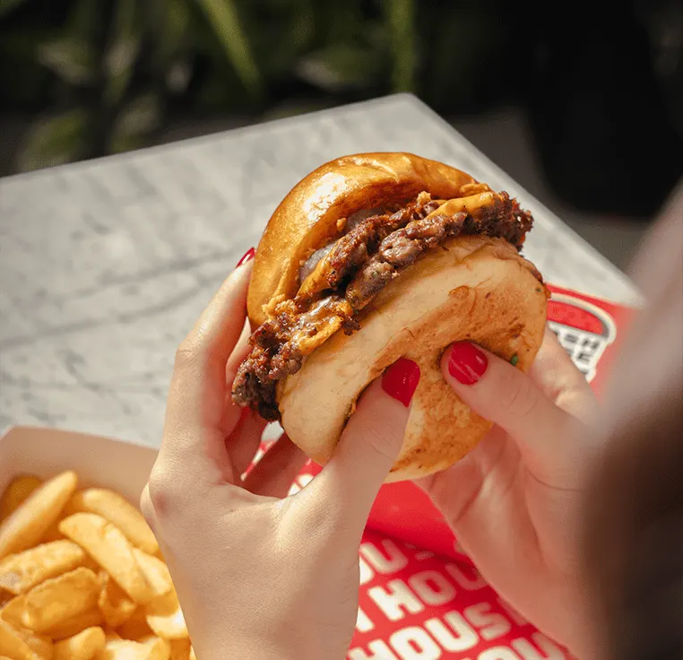 Elde tutulan, eriyen peynirli çift köfteli smash burger